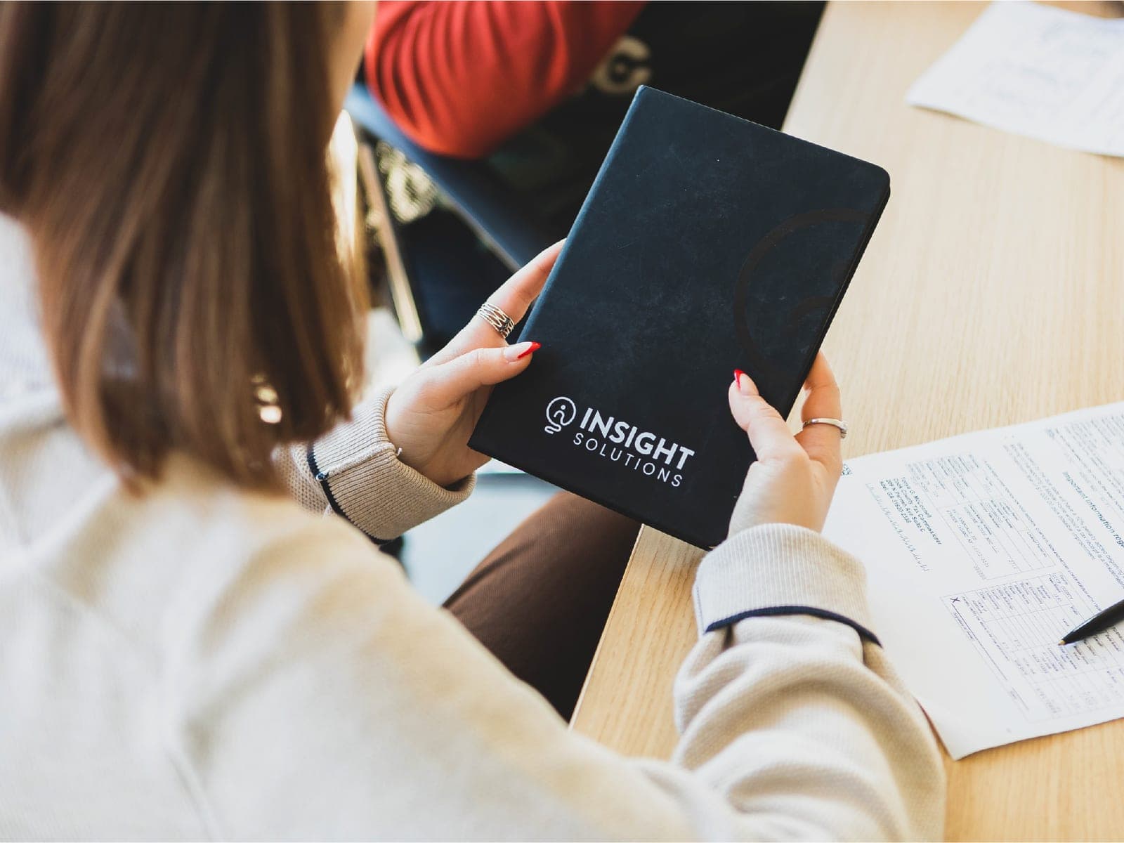 An Insight Solutions branded notebook in a client meeting